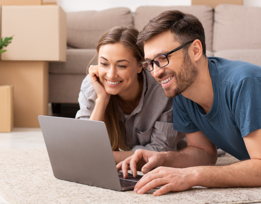 about Man and woman smiling looking at a laptop