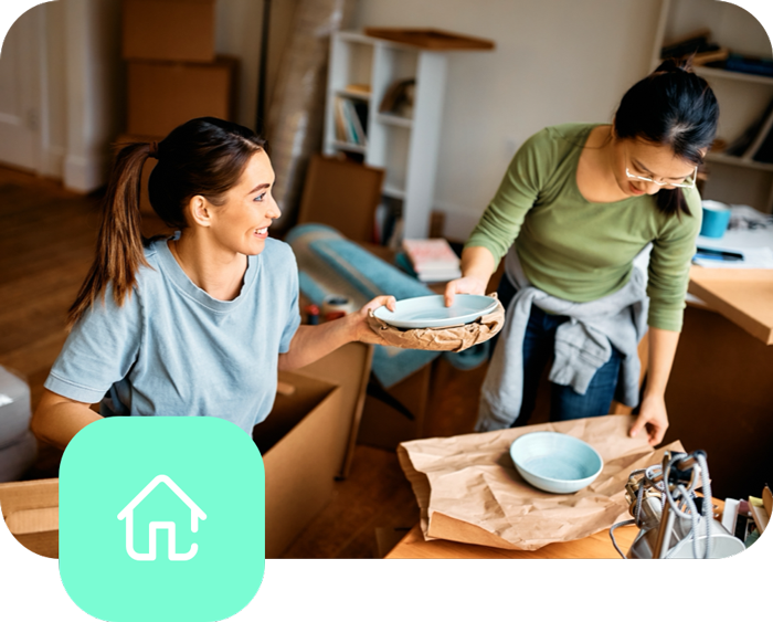 two women smiling passing plates